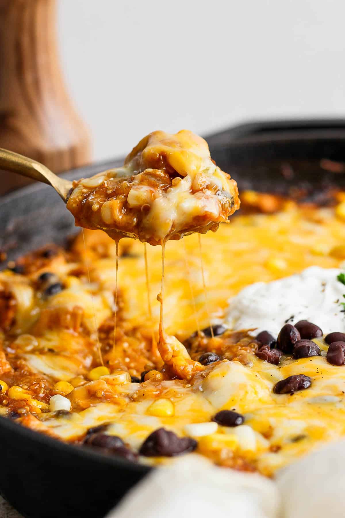 A spoon scooping up a spoonful of quinoa enchilada bake.