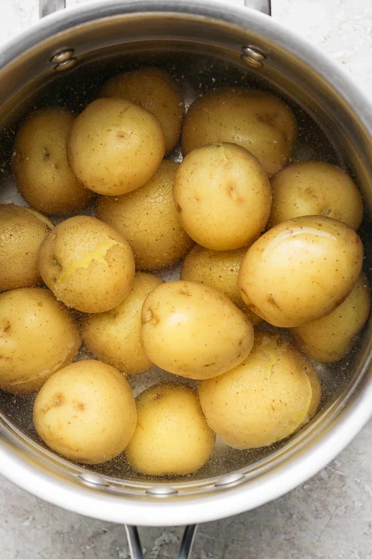 Small potatoes boiling in a pot of water.