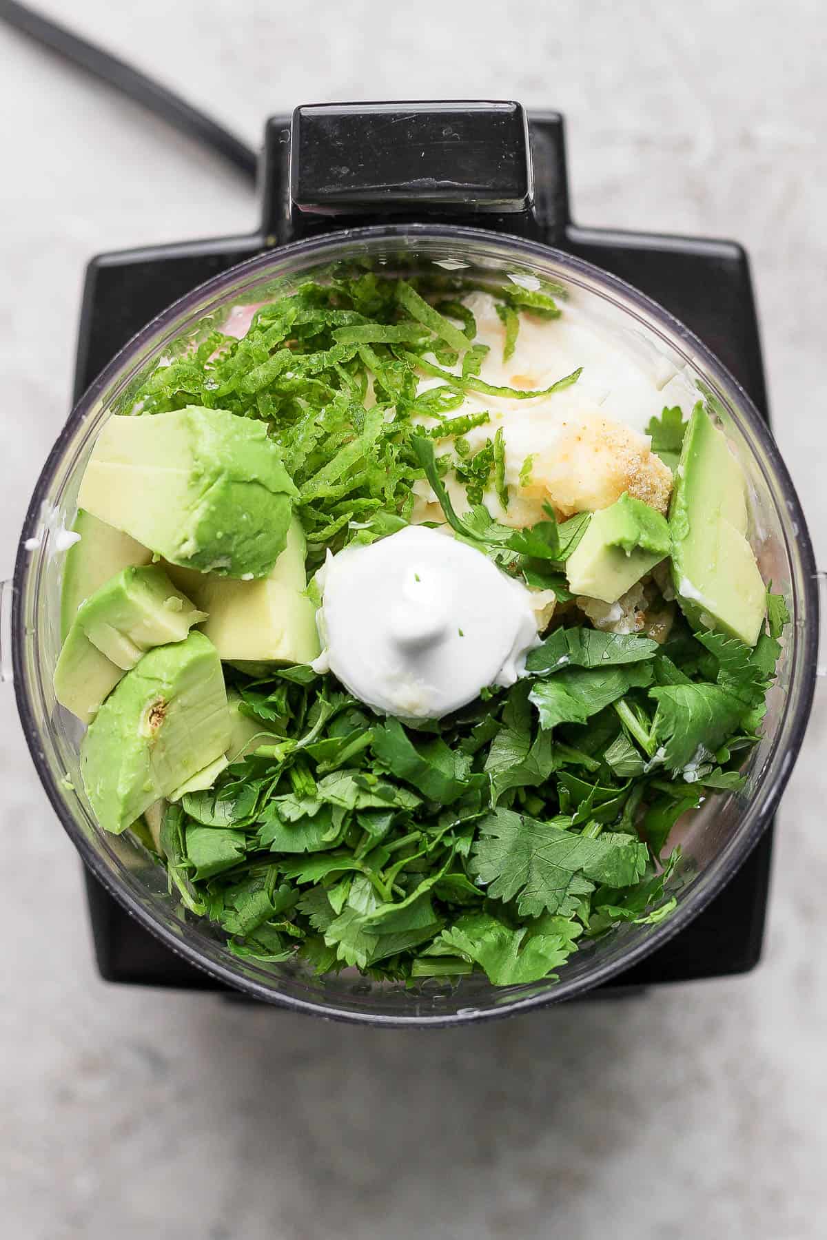 Avocado Lime ranch dressing ingredients in a small food processor, unblended.