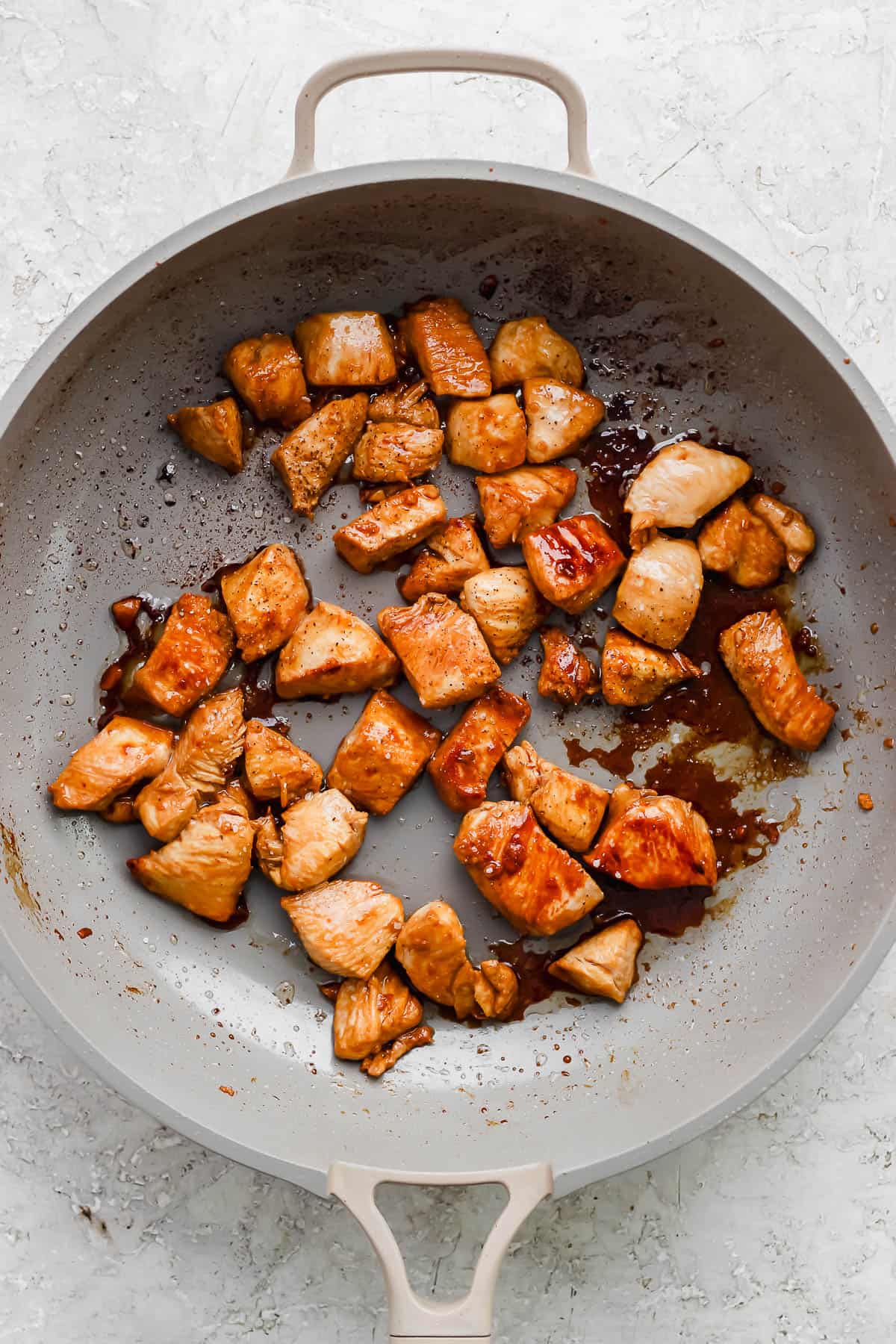 Marinated chicken cooked in a skillet.