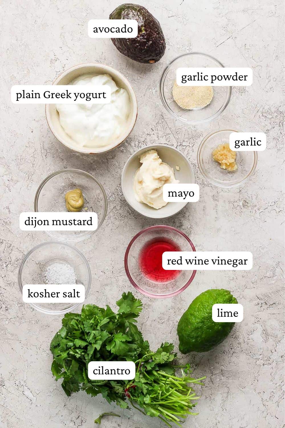 Ingredients for cilantro lime ranch dressing: avocado, greek yogurt, mayo, cilantro, red wine vinegar, garlic powder, dijon mustard, minced garlic, salt, pepper, and a whole lime.