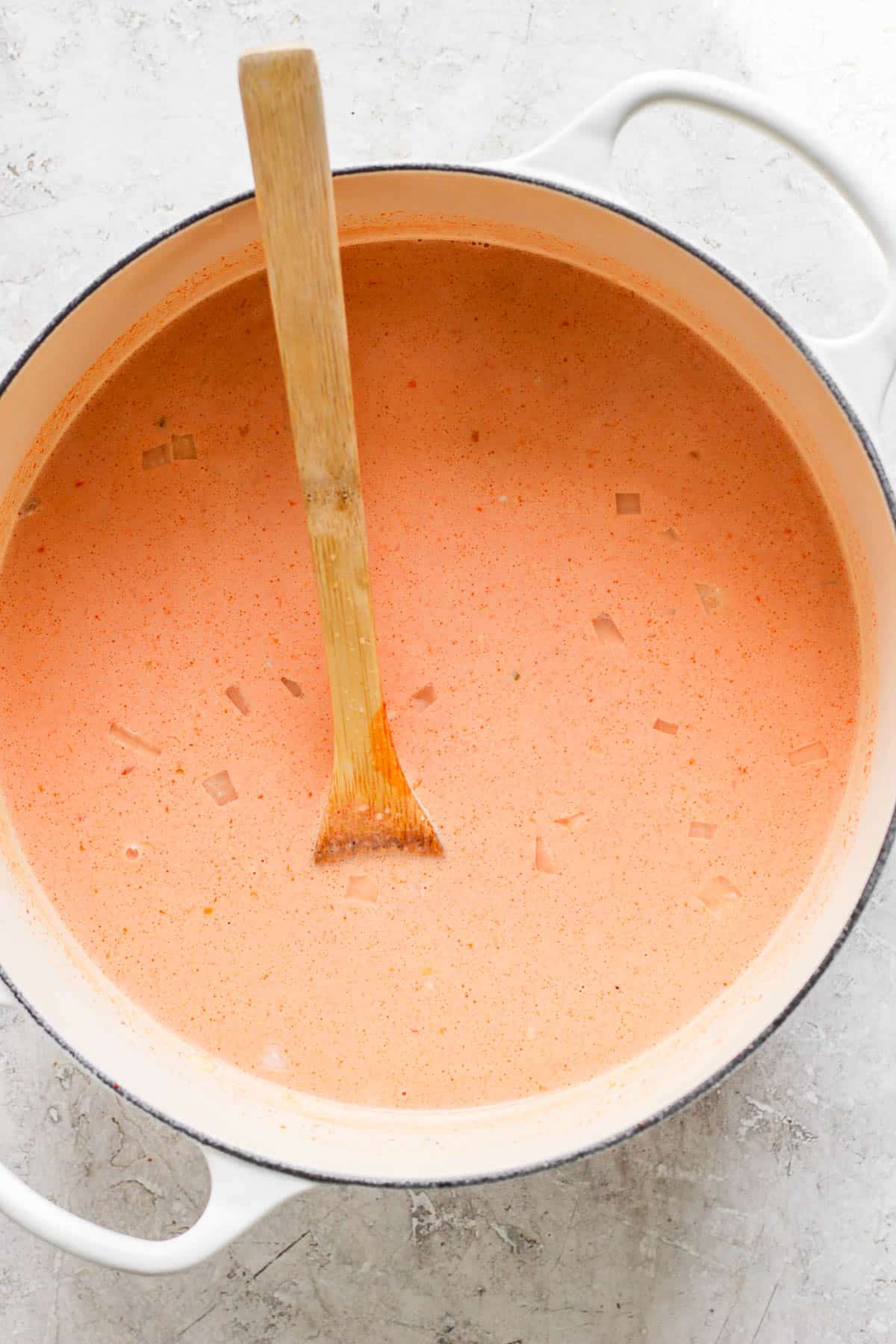 The entire broth mixed together in the pot with a wooden spoon.