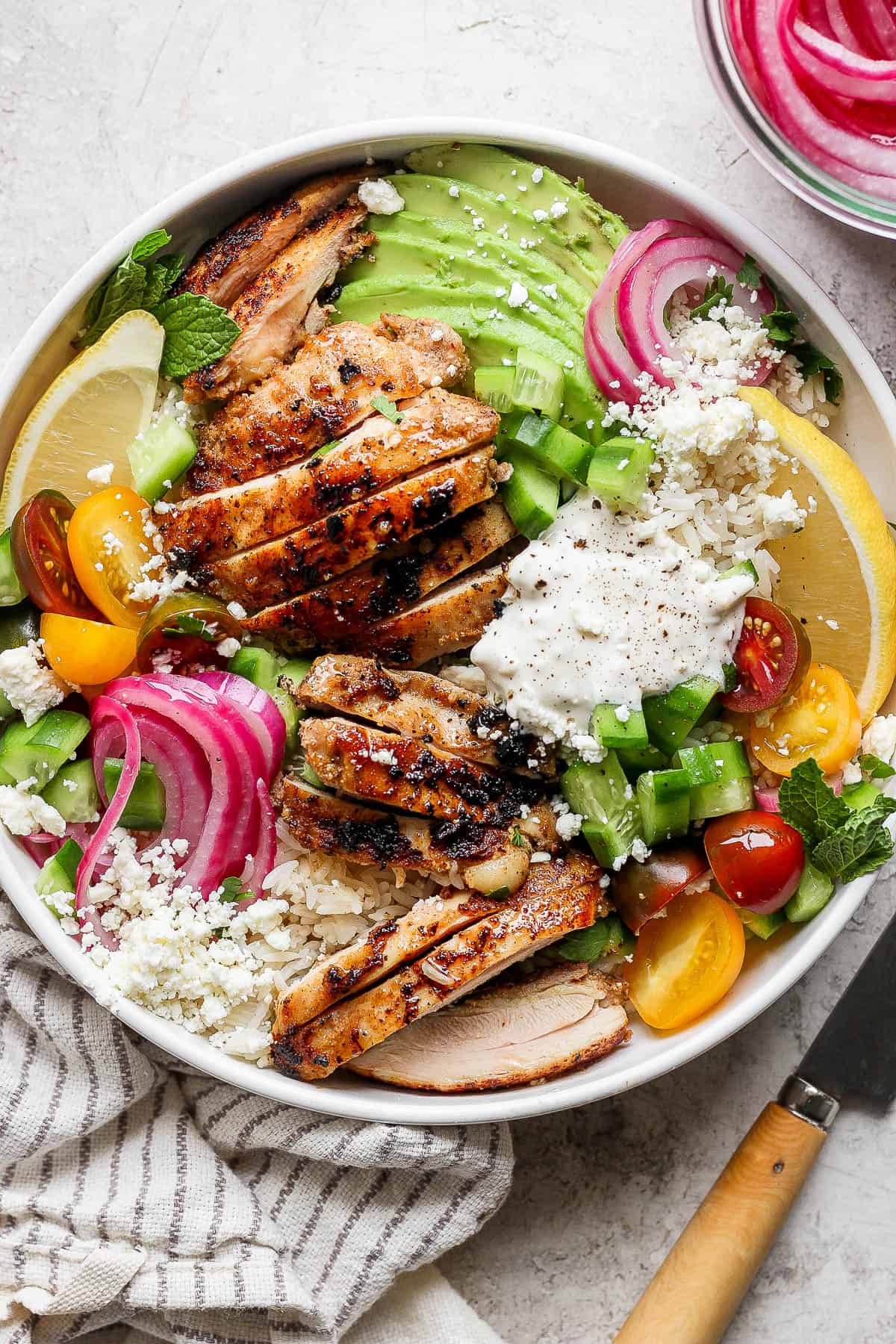 The garlic white sauce on top of a chicken shawarma bowl.