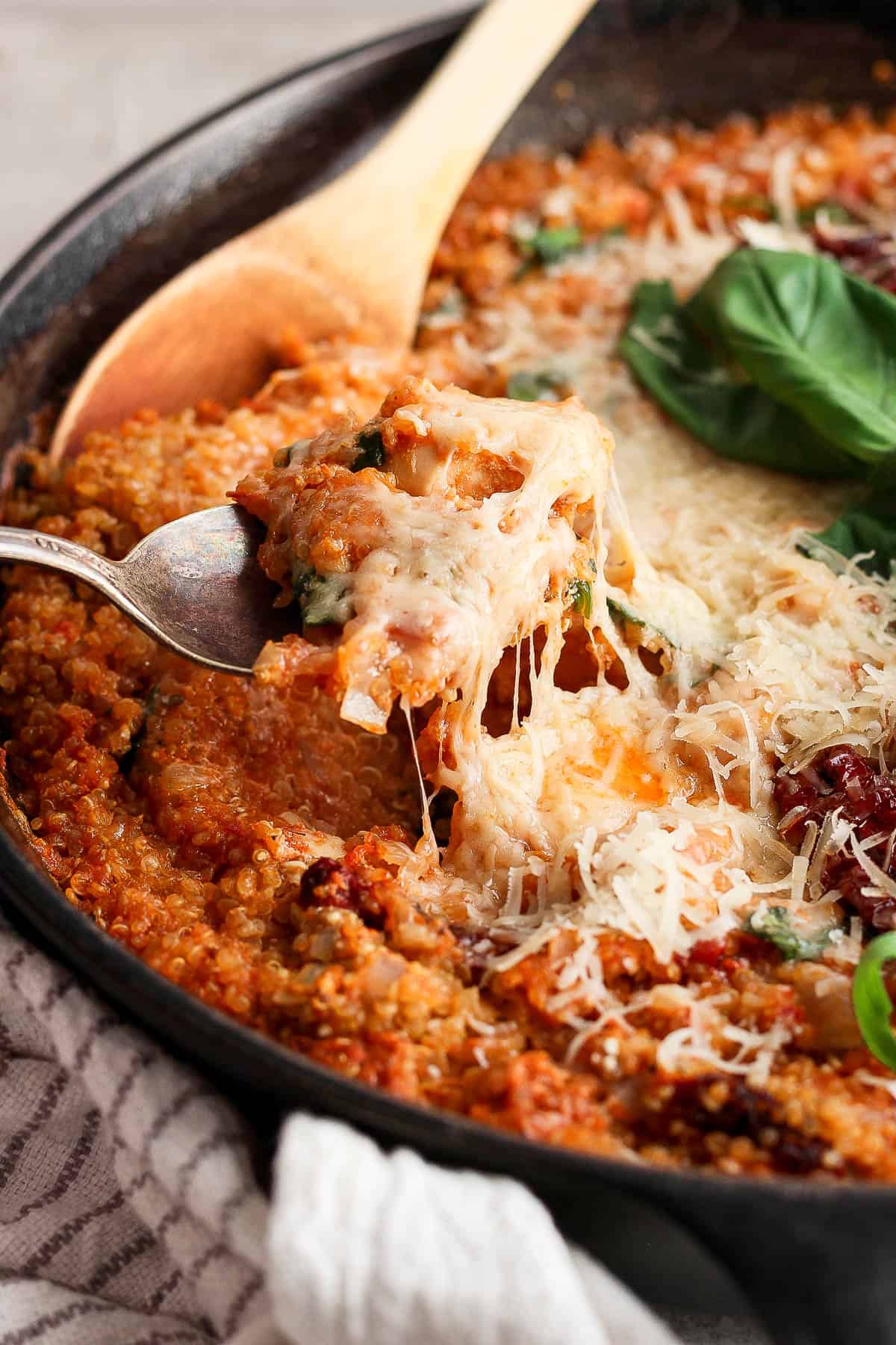 A spoon pulling a spoonful of the marry me chicken quinoa skillet.