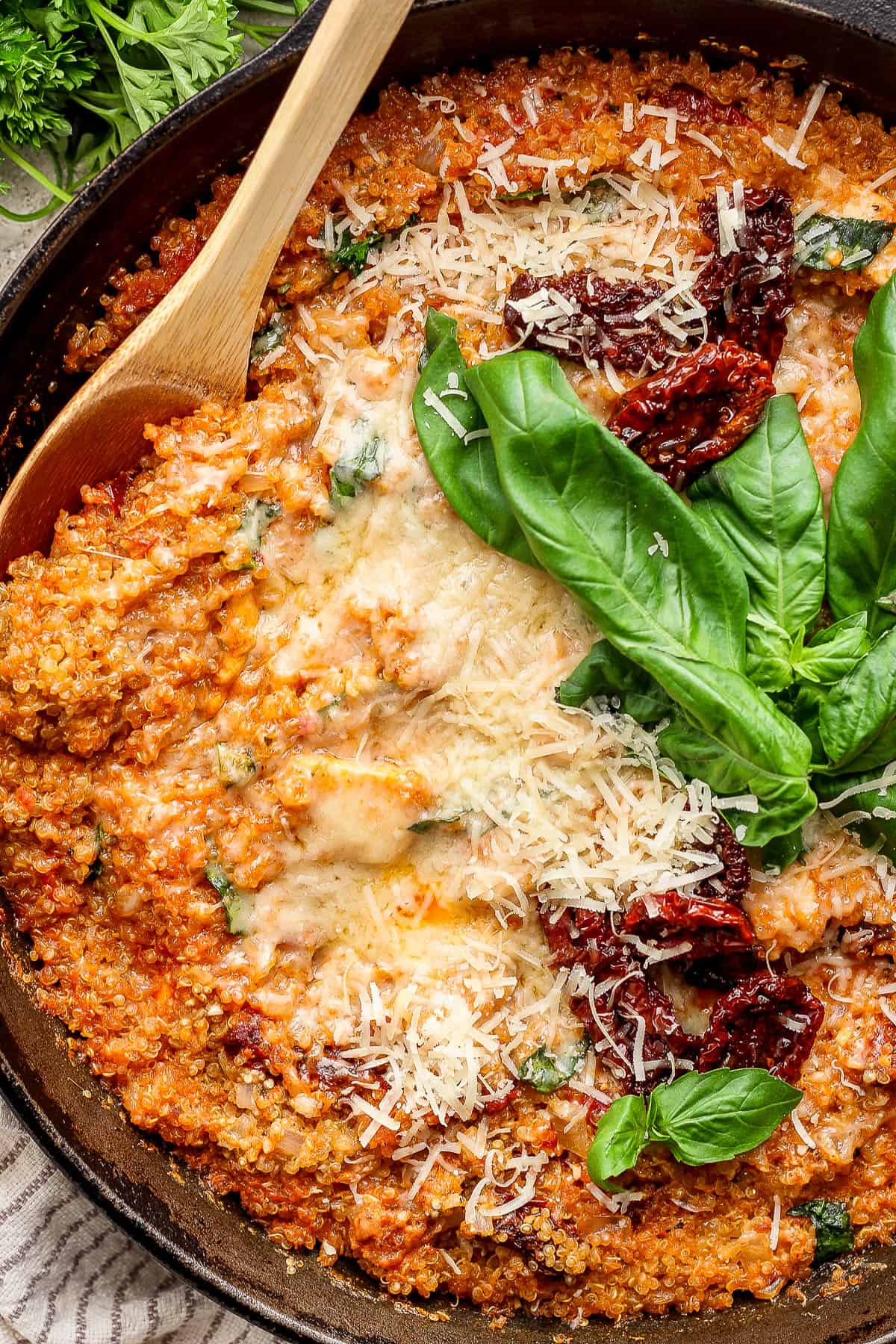 Close up of marry me chicken quinoa skillet garnished with fresh basil.