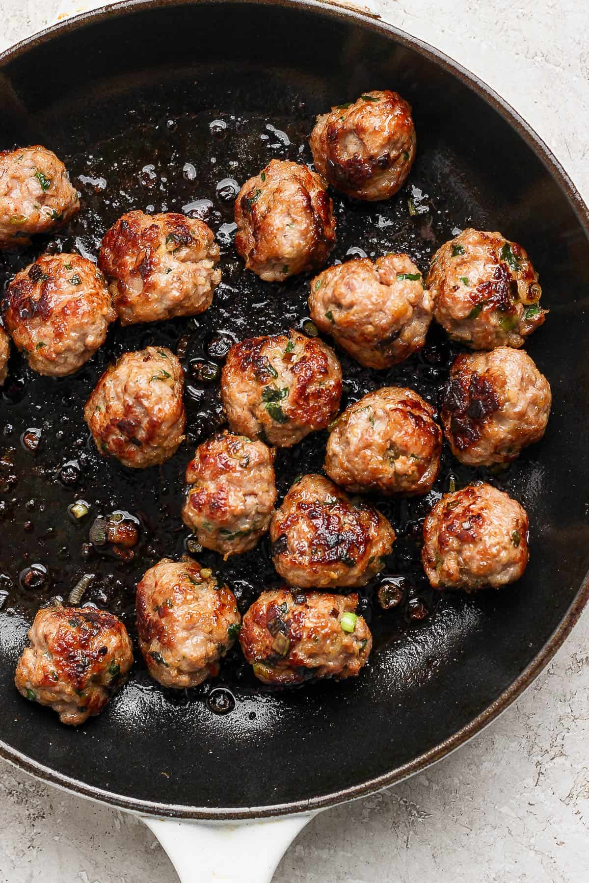 Pork meatballs in a cast iron skillet. 