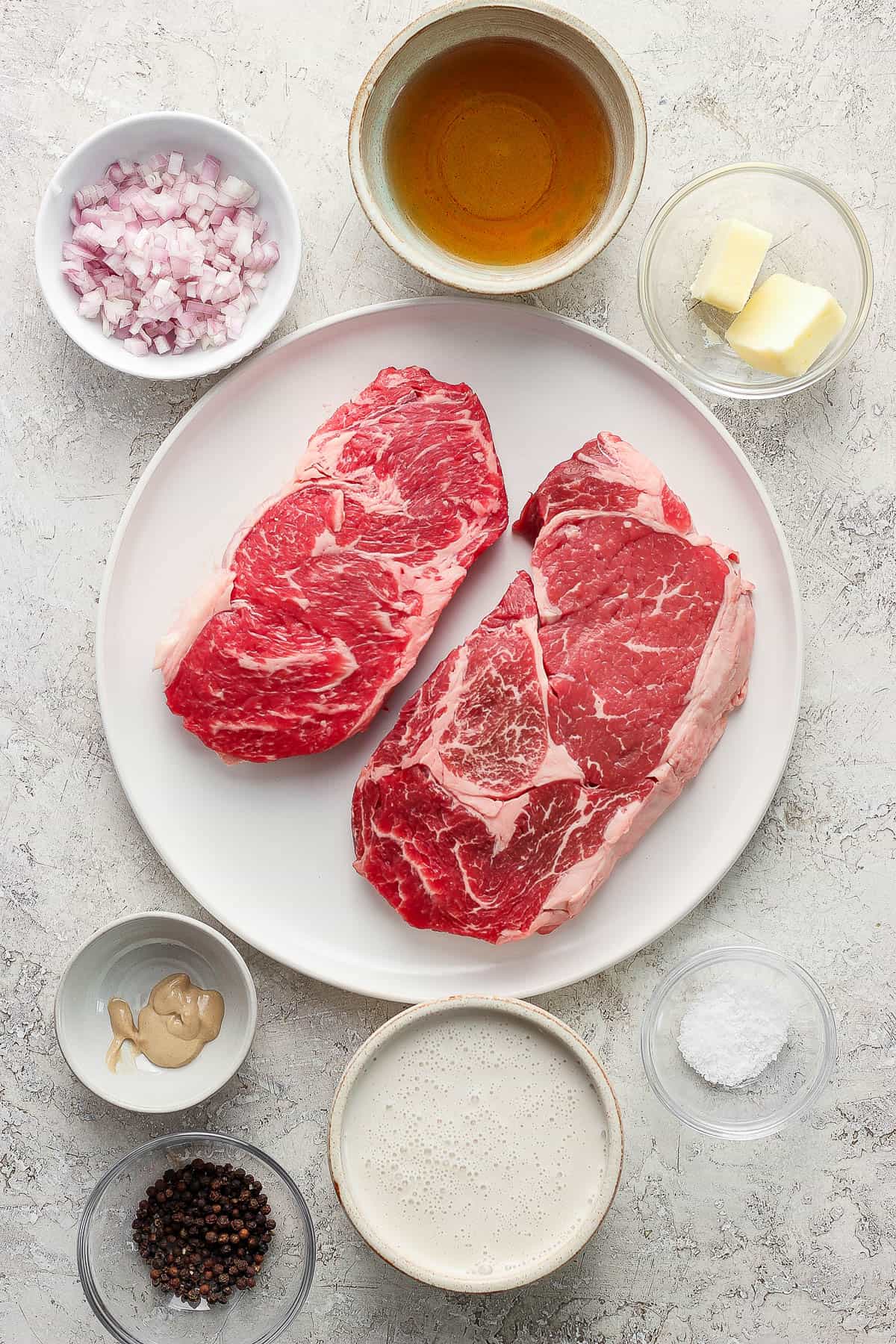 Ingredients for steak au poivre in separate bowls.