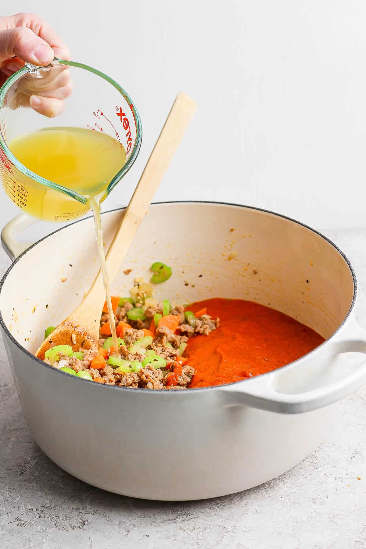 Chicken broth being poured into the pot.