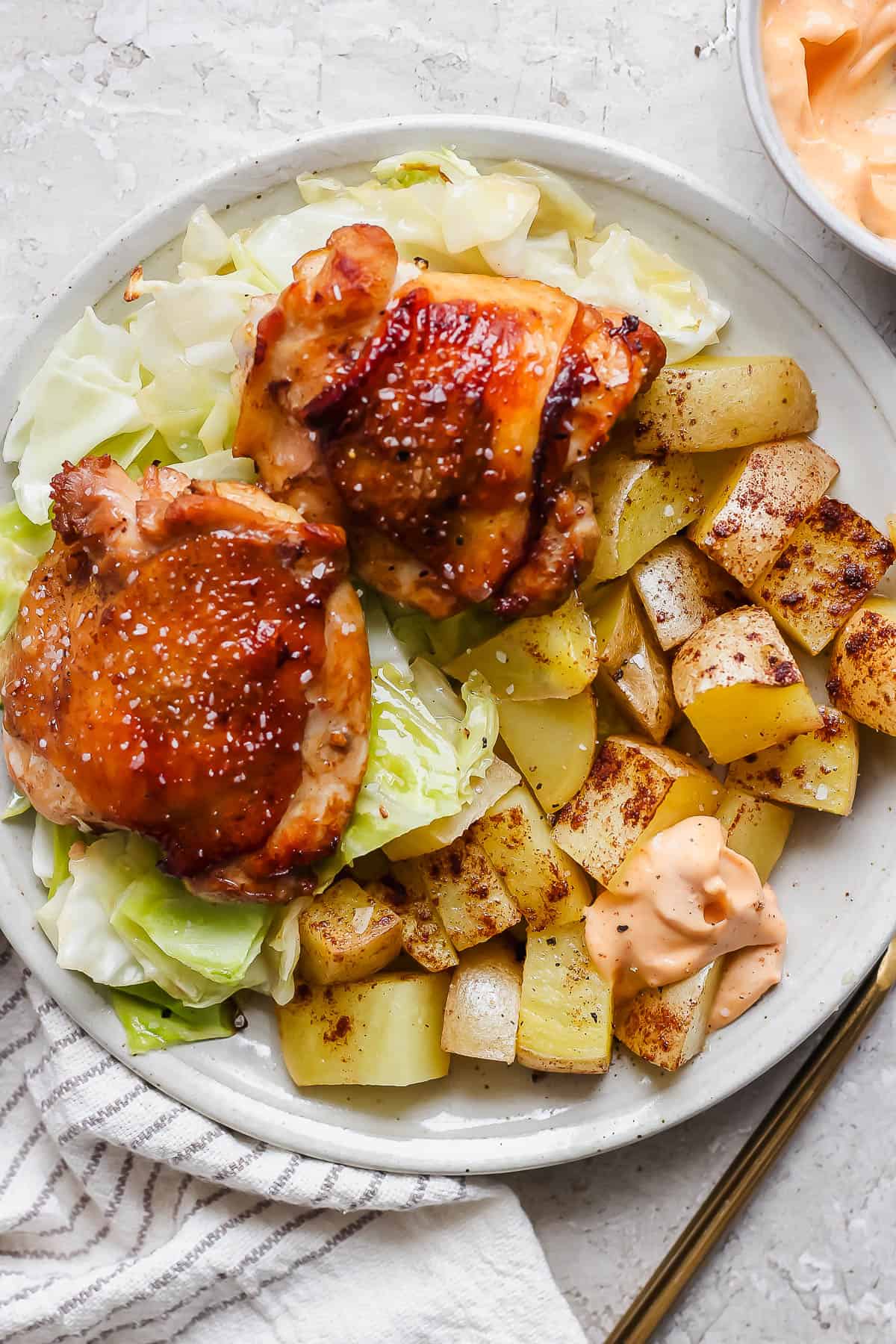 Gochujang mayo on the side of a sheet pan chicken thighs dinner.