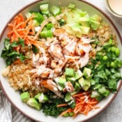 A big bowl of crispy rice salad with salmon, carrots, avocado, cucumber and cilantro.