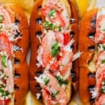 Close up top shot of a grilled crab roll with a top cut hot dog bun with grill marks and stuffed with grilled crab meat.