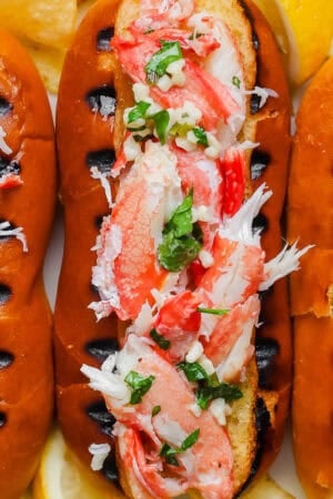 Close up top shot of a grilled crab roll with a top cut hot dog bun with grill marks and stuffed with grilled crab meat.