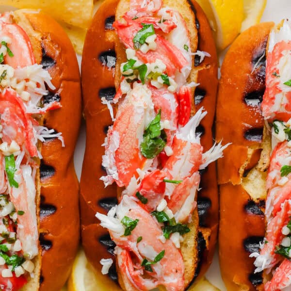 Close up top shot of a grilled crab roll with a top cut hot dog bun with grill marks and stuffed with grilled crab meat.