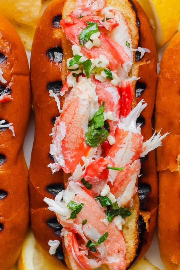 Close up top shot of a grilled crab roll with a top cut hot dog bun with grill marks and stuffed with grilled crab meat.