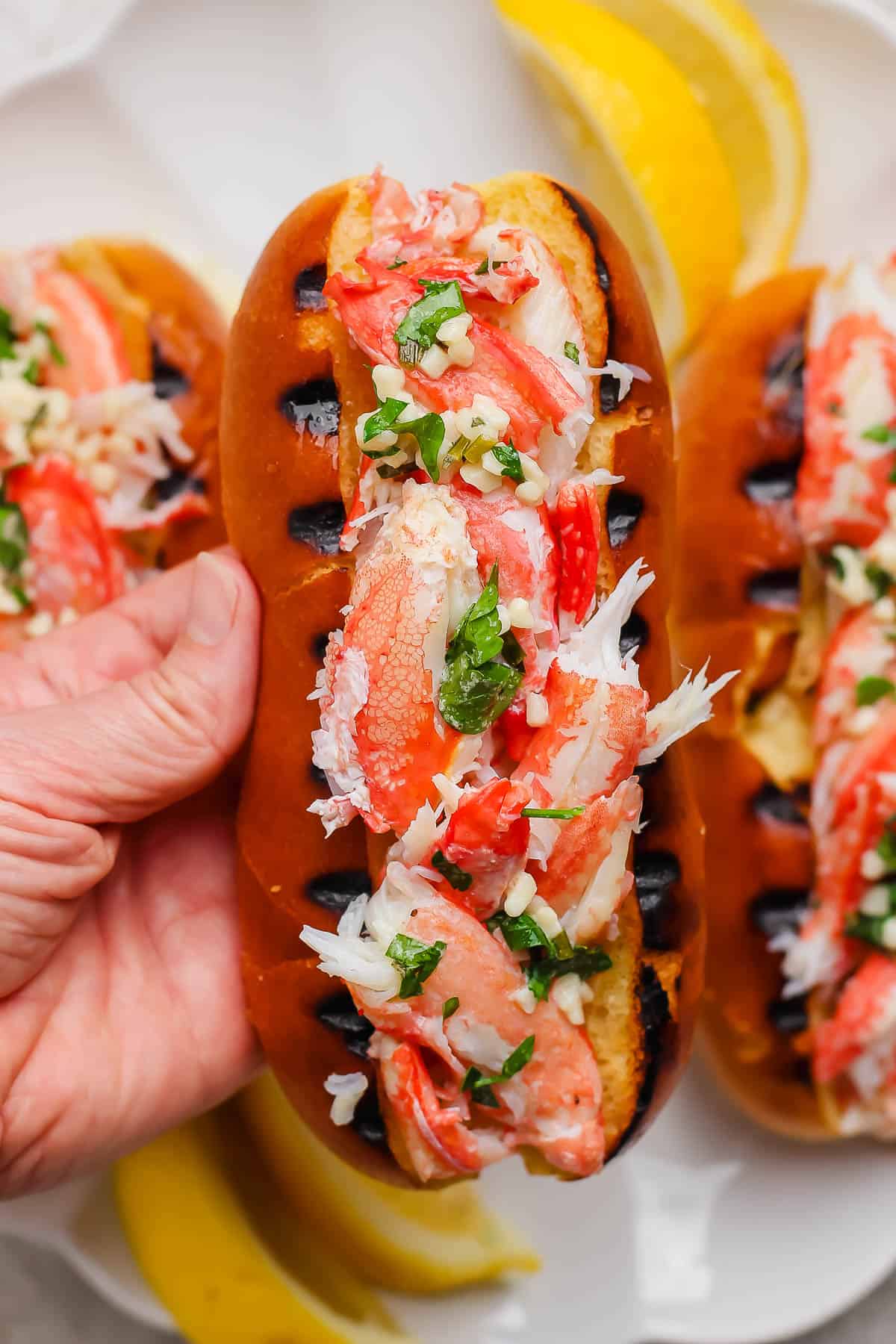 A hand holding a warm crab roll.