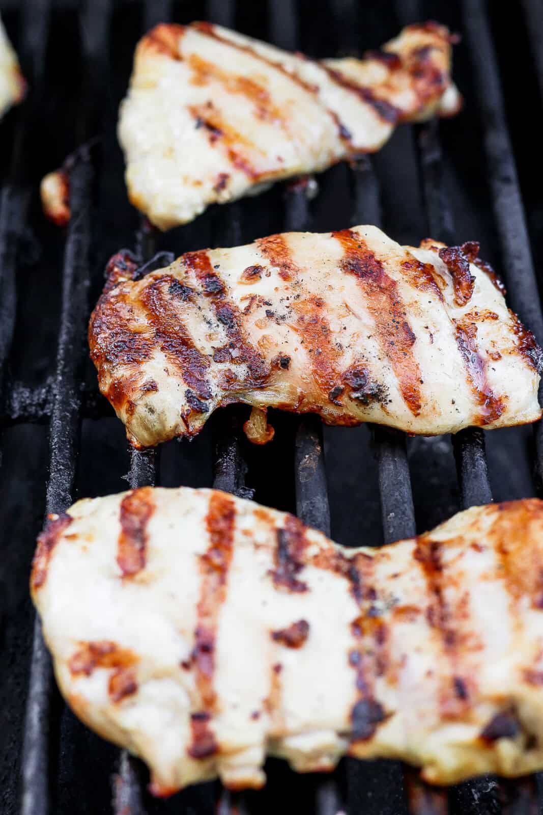 Chicken thighs cooking on the grill.