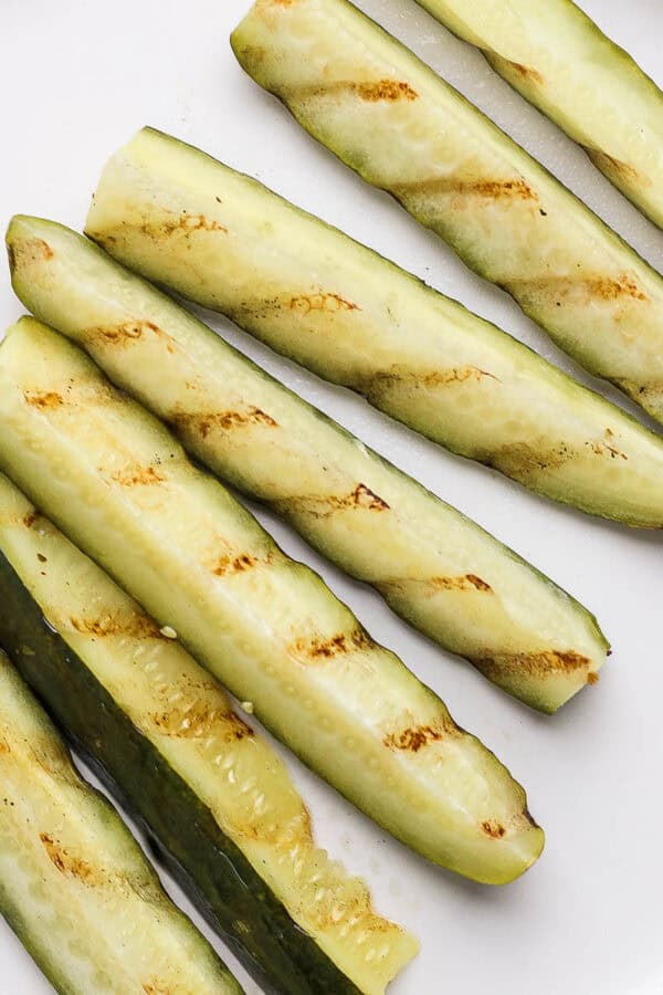 A plate of grilled pickles with grill marks.