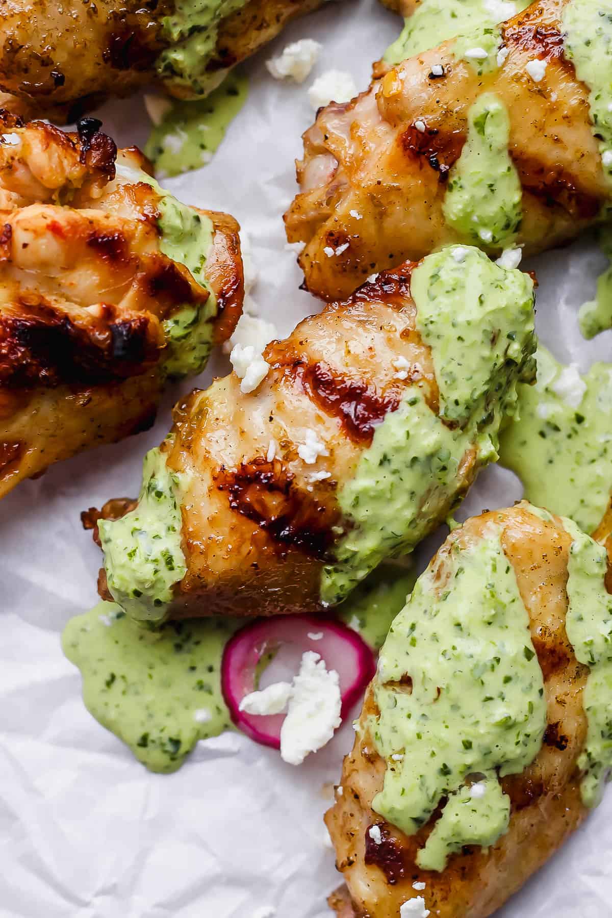 Chicken wings slathered with peruvian green sauce slathered over the top.