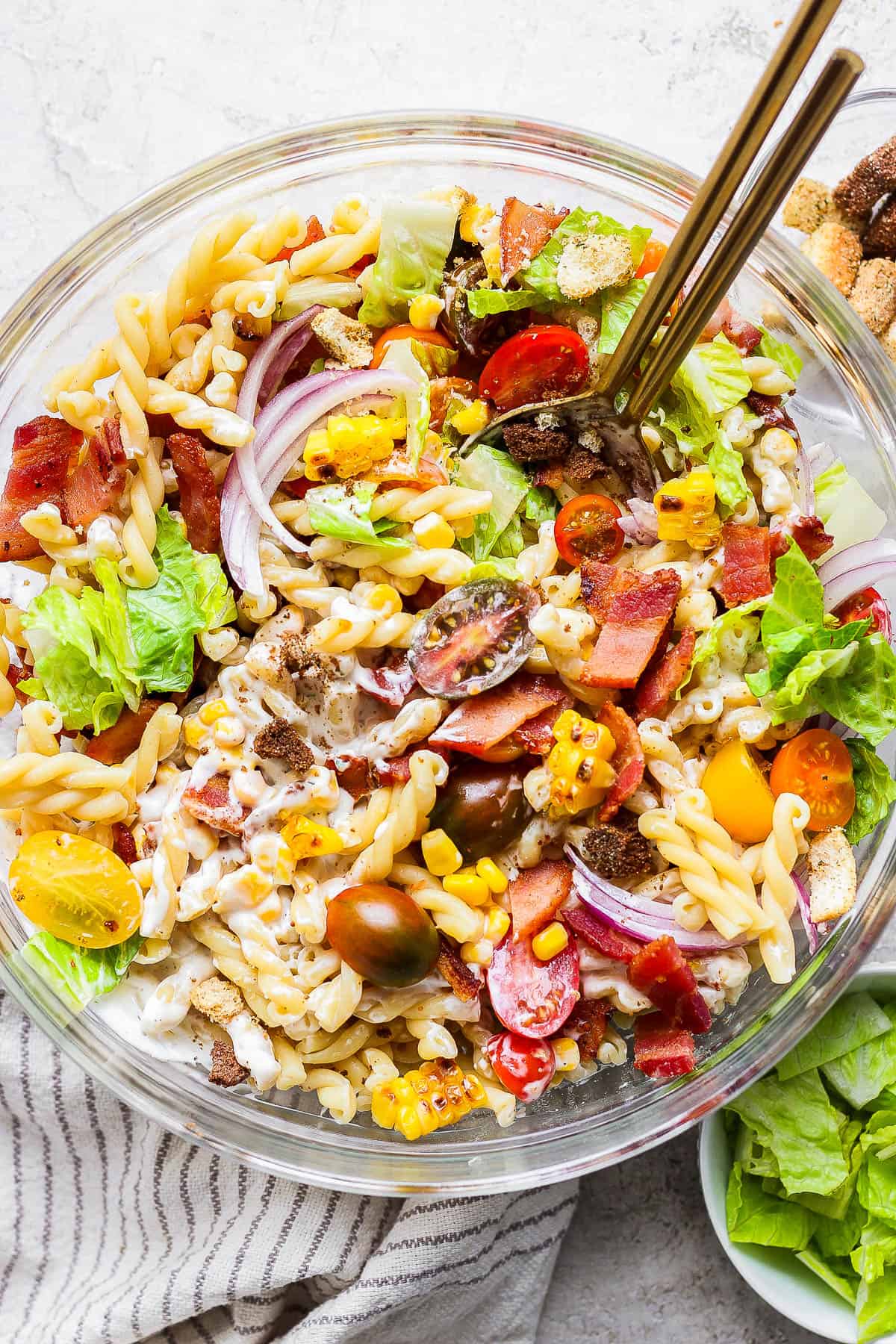 Bacon ranch pasta salad in a bowl with two spoons.