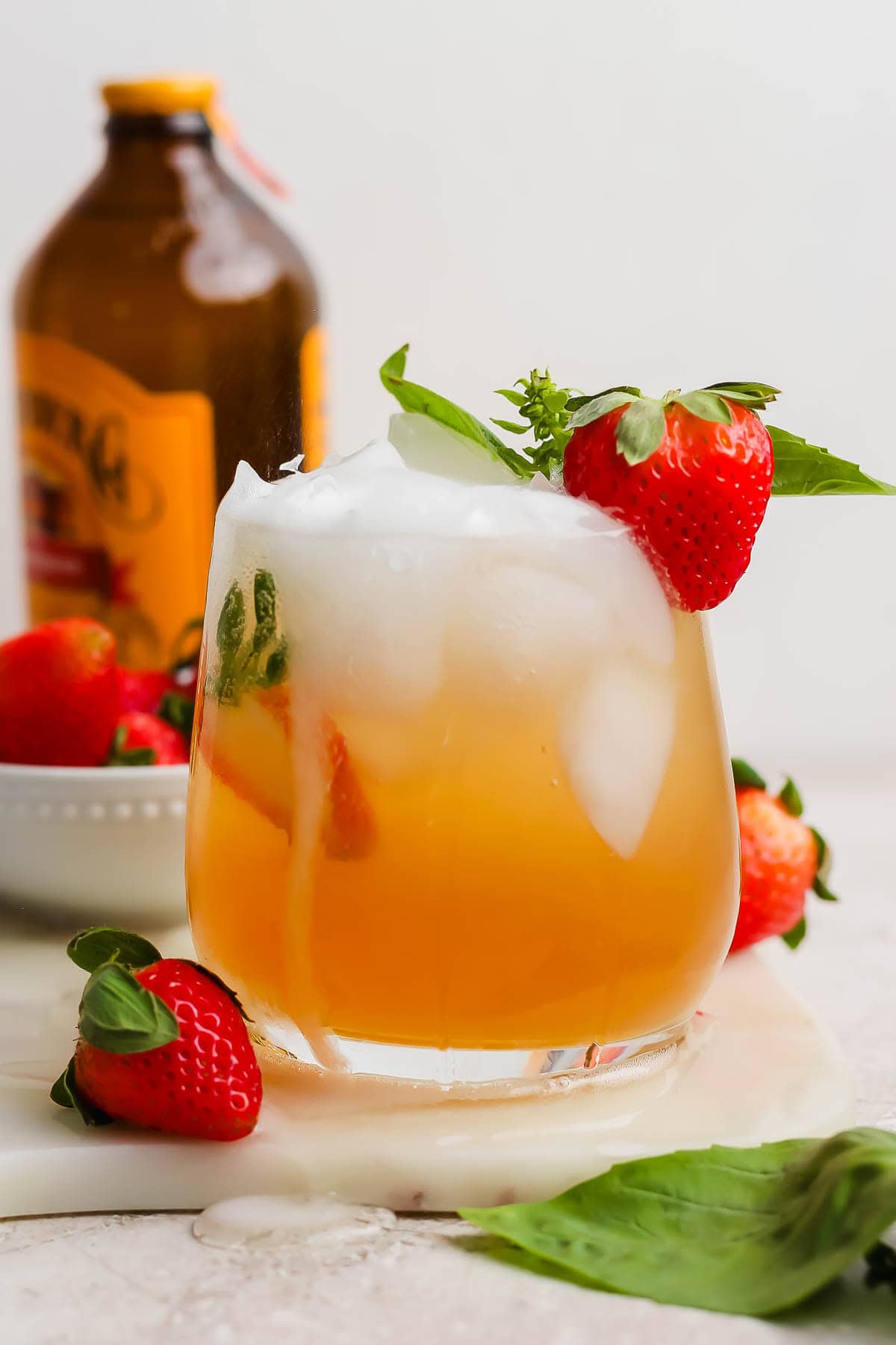 A Kentucky Buck cocktail in a glass with a strawberry on the side.