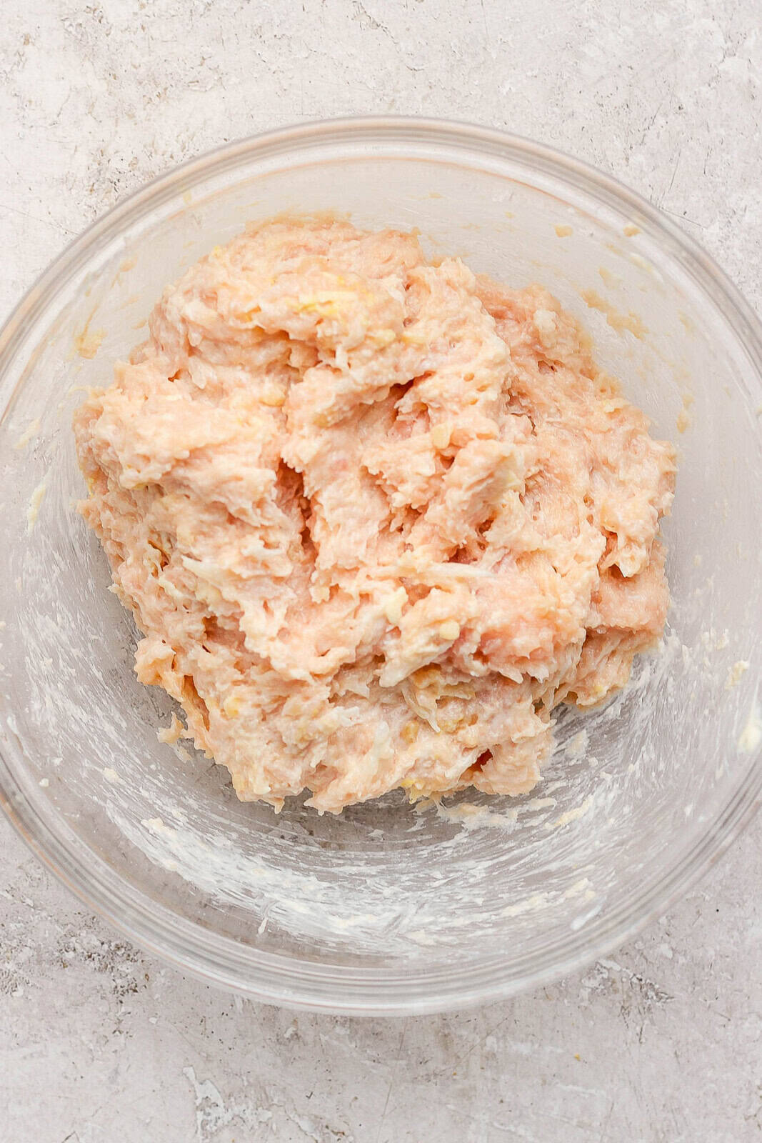 Ground chicken, mayo, garlic, onion, lemon, and parmesan mixed together in a bowl.