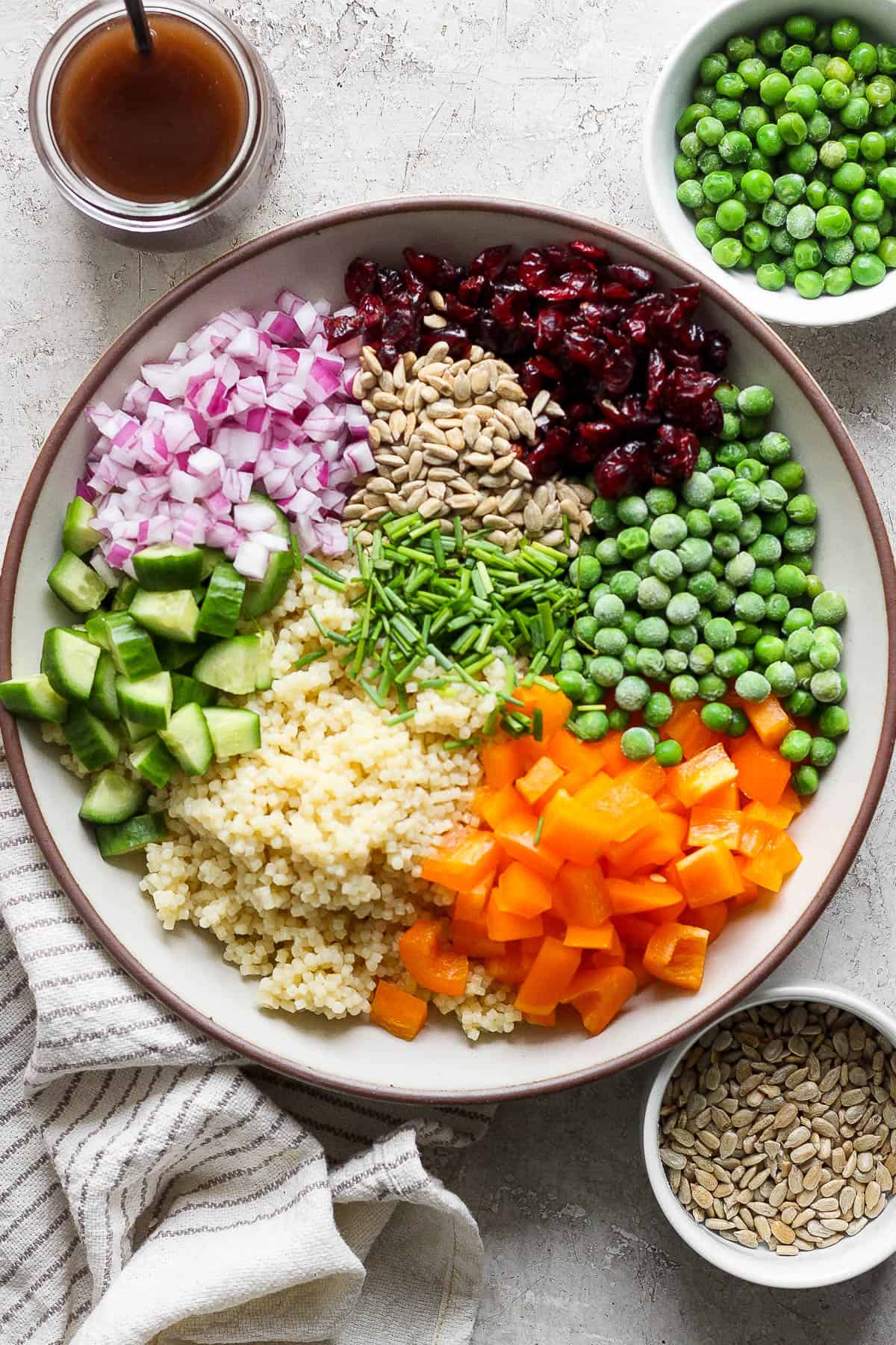 The pieces of the acini di pepe salad in a large bowl but not mixed together.
