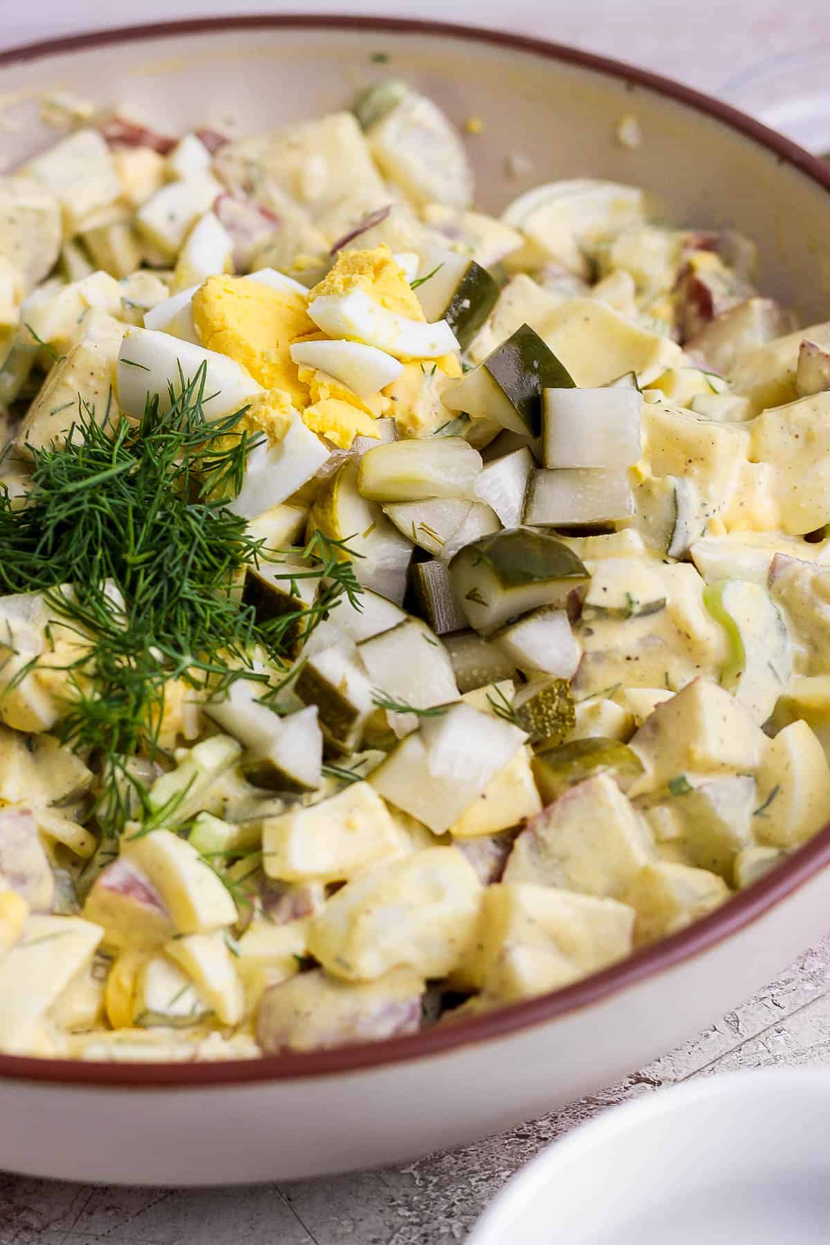 Dill pickle potato salad in a bowl, mixed.