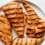 A plate of grilled chicken cutlets.