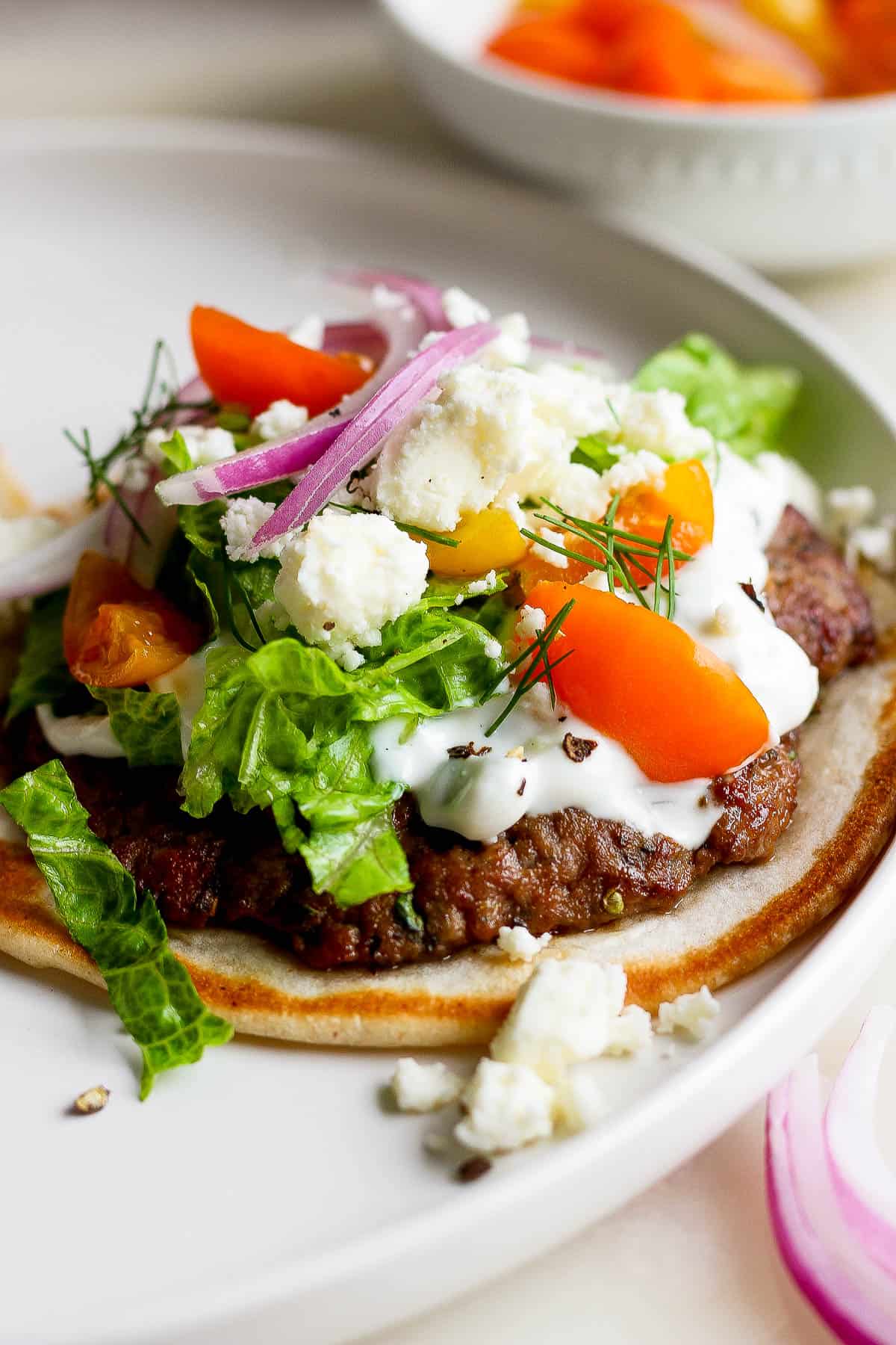 A fully assembled gyro smash burger taco on a plate.