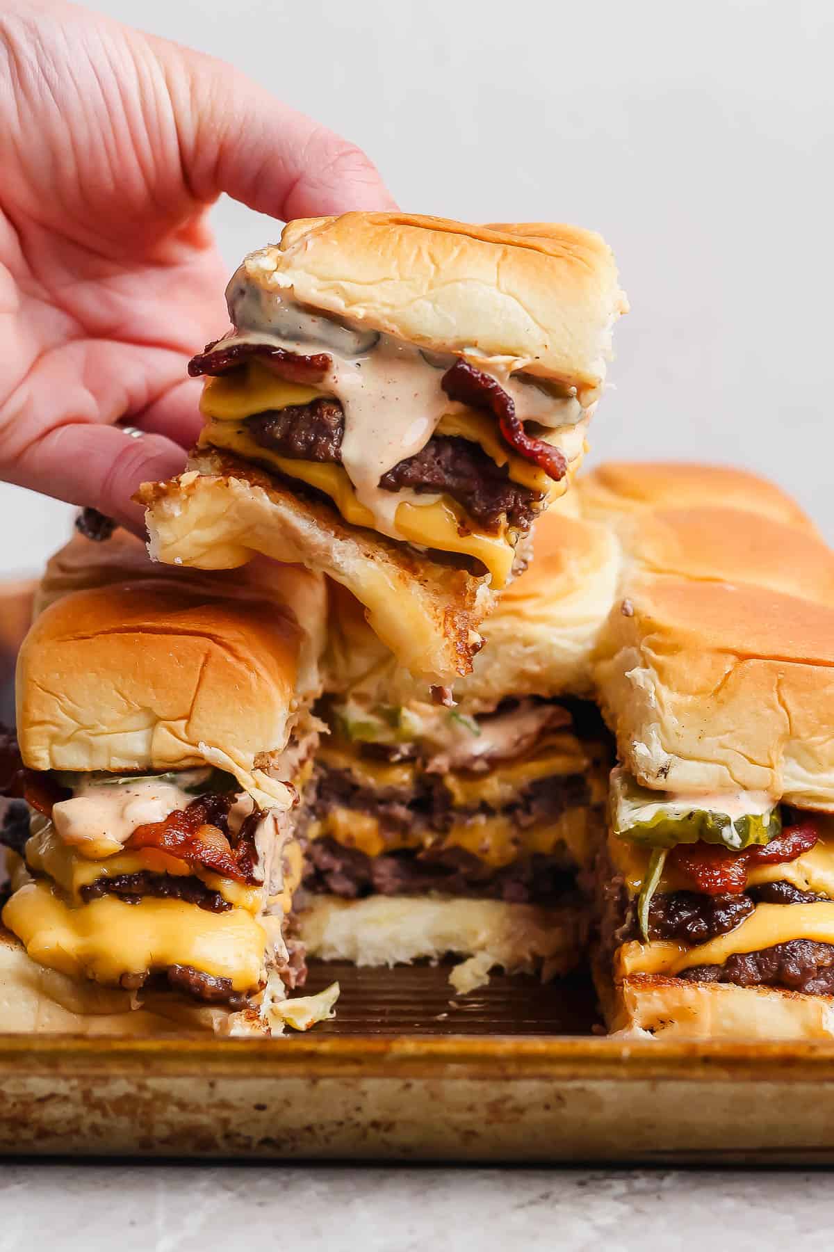 A hand pulling a slider from the pan.