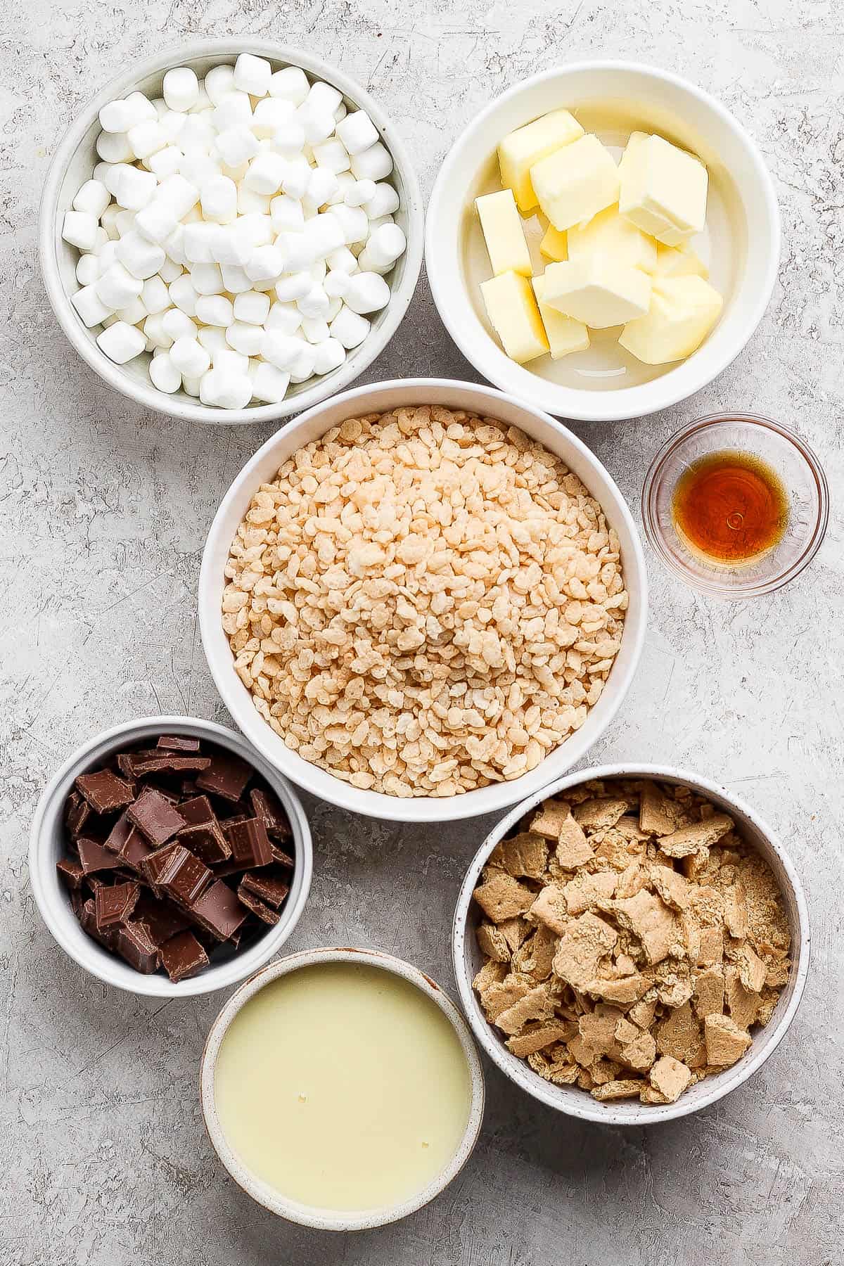 Ingredients for s'mores rice krispie treats in separate bowls.