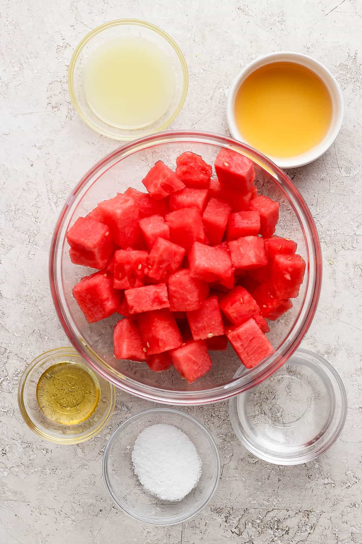 Ingredients for watermelon margaritas in separate bowls.