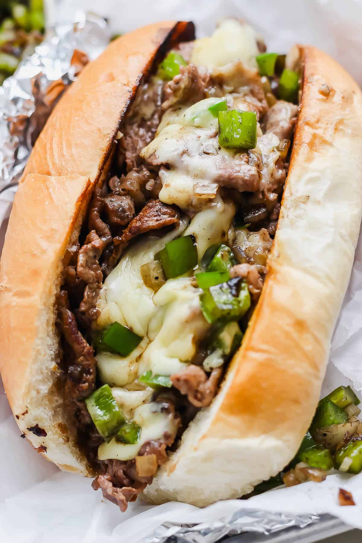 A philly cheesesteak sandwich wrapped in foil.
