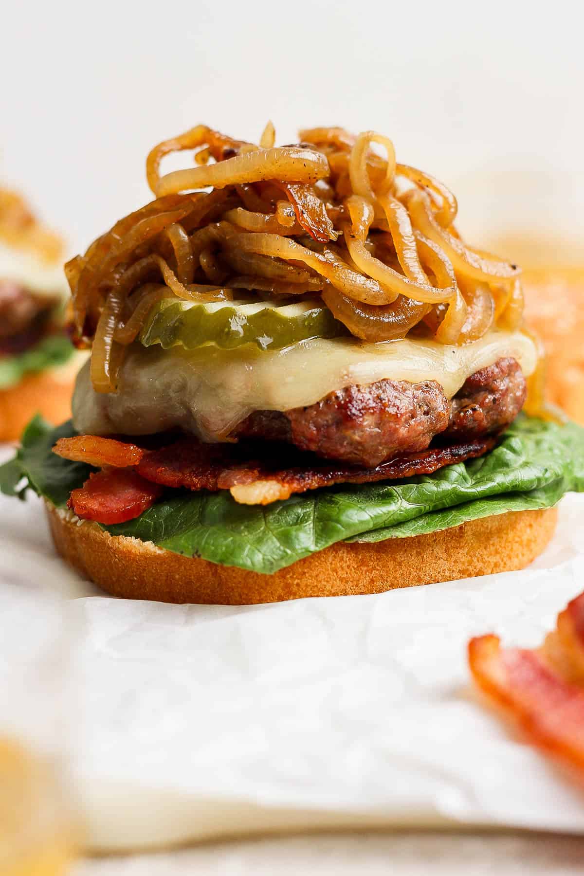 A burger being assembled with all the toppings.