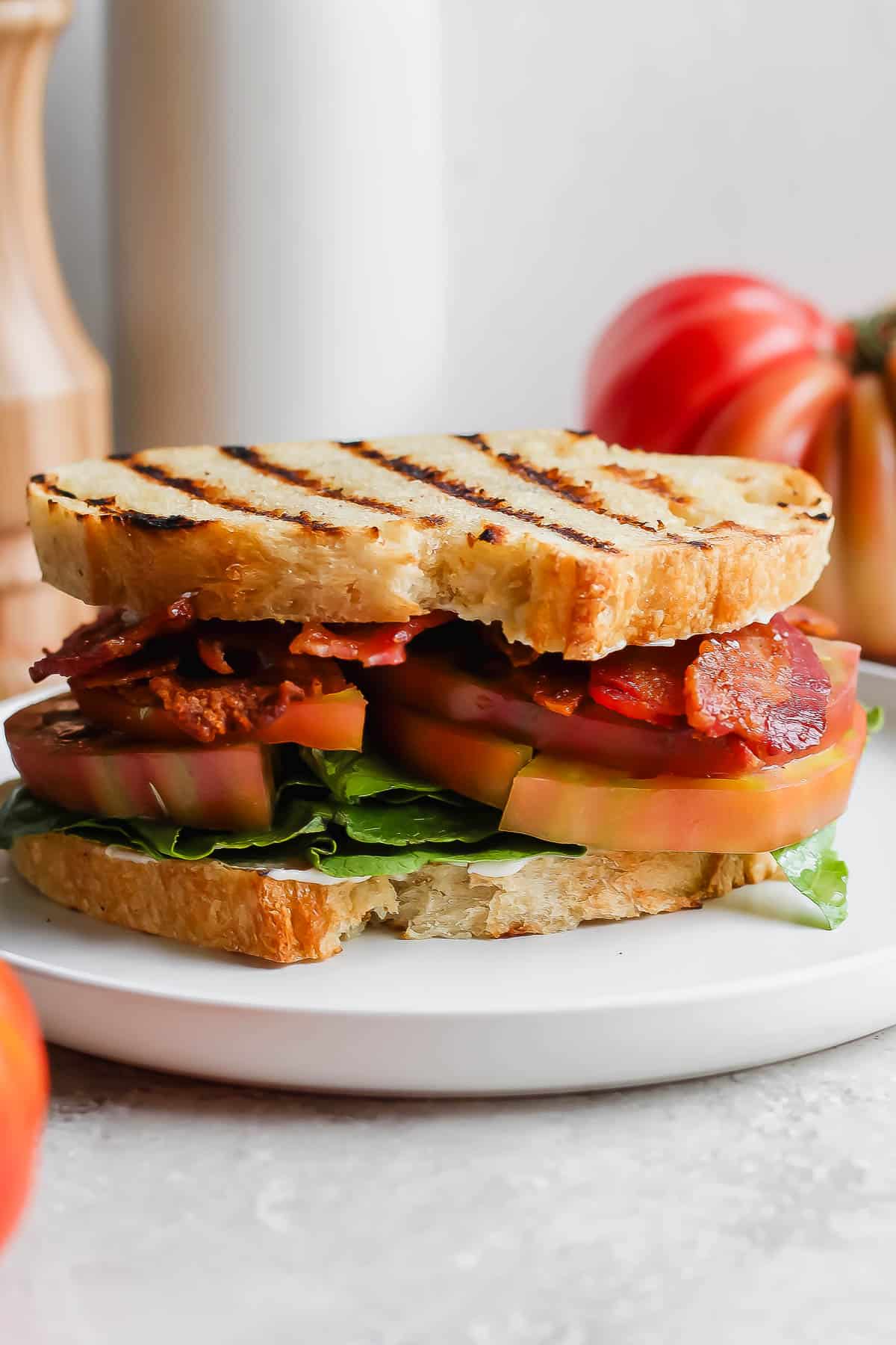 A fully assembled grilled BLT on a plate.
