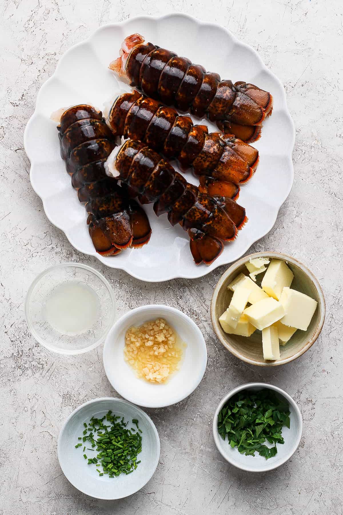 Ingredients for grilled lobster in separate bowls.