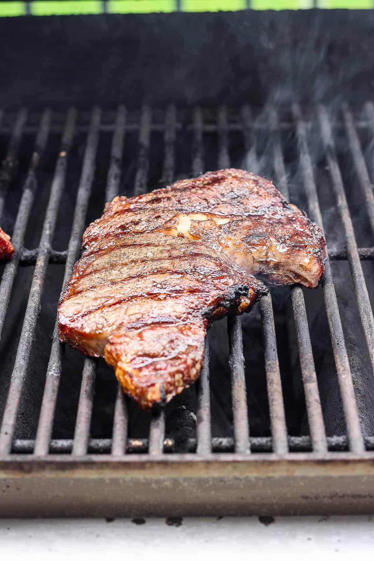 A ribeye steak on the grill.