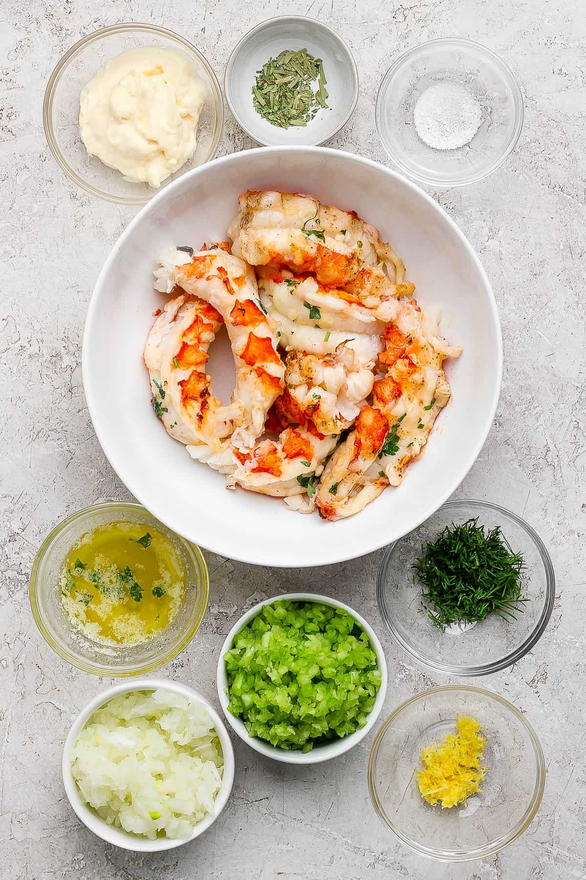 Ingredients for lobster salad in separate bowls.