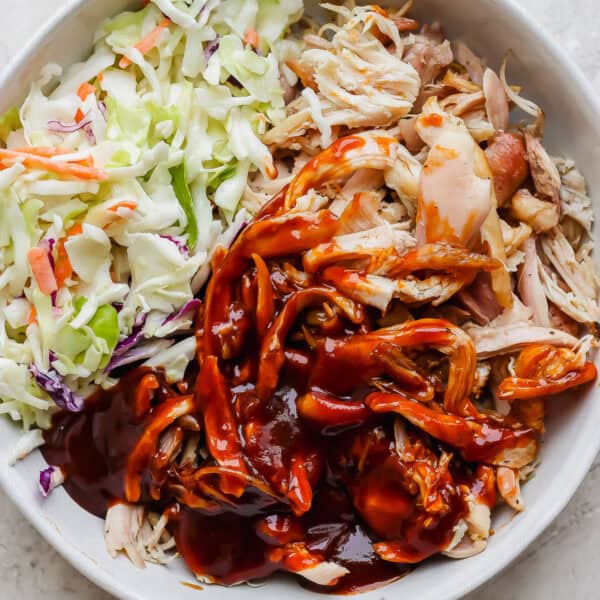 A bowl of smoked pulled chicken with bbq sauce and coleslaw.