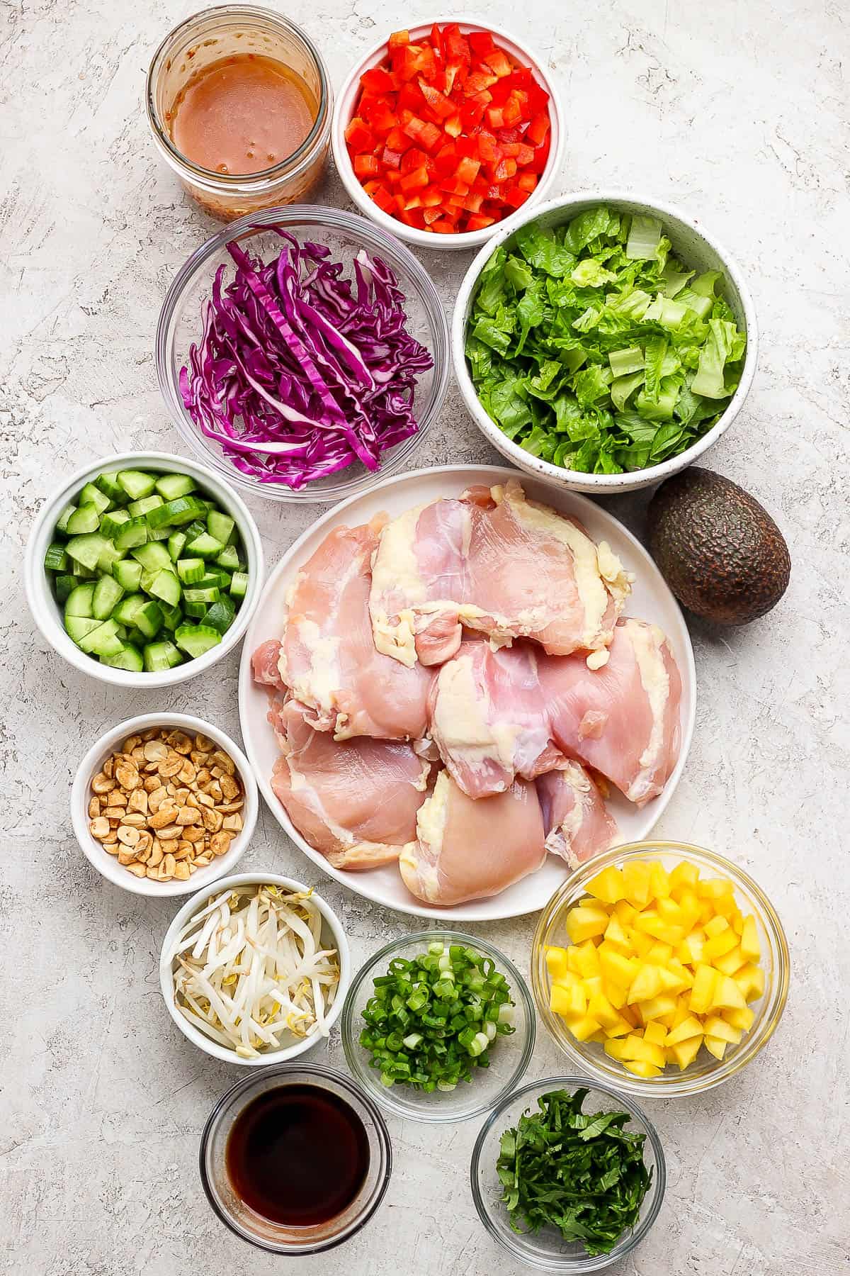 Ingredients for a spring roll salad in separate bowls.