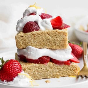 Gluten free strawberry shortcake on a plate topped with whipped cream and strawberries