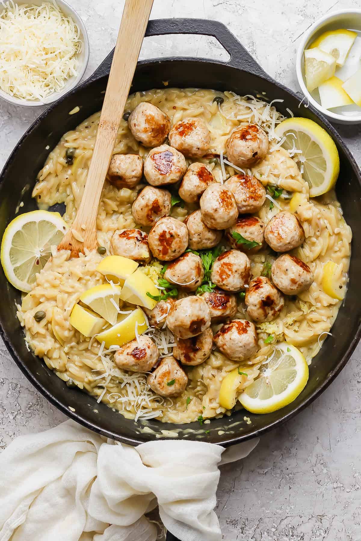 Cooked meatballs added back to the skillet of orzo.