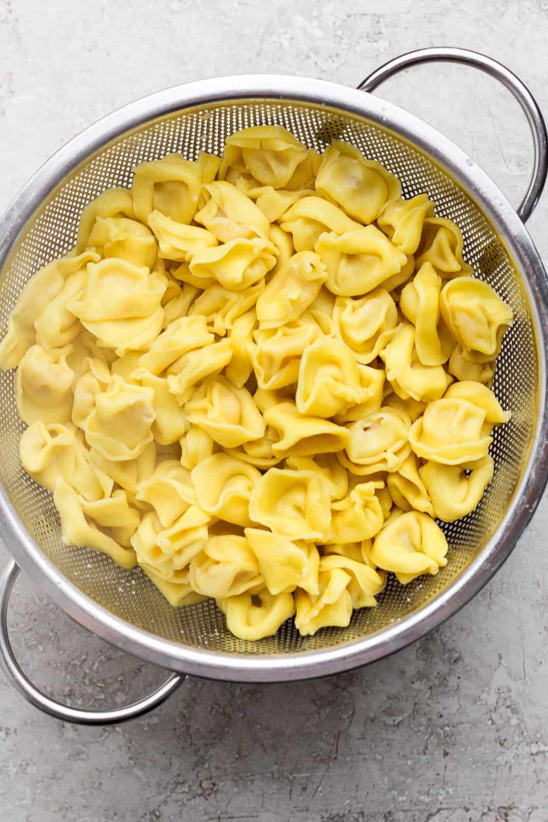 Cooked cheese tortellini in a colander.
