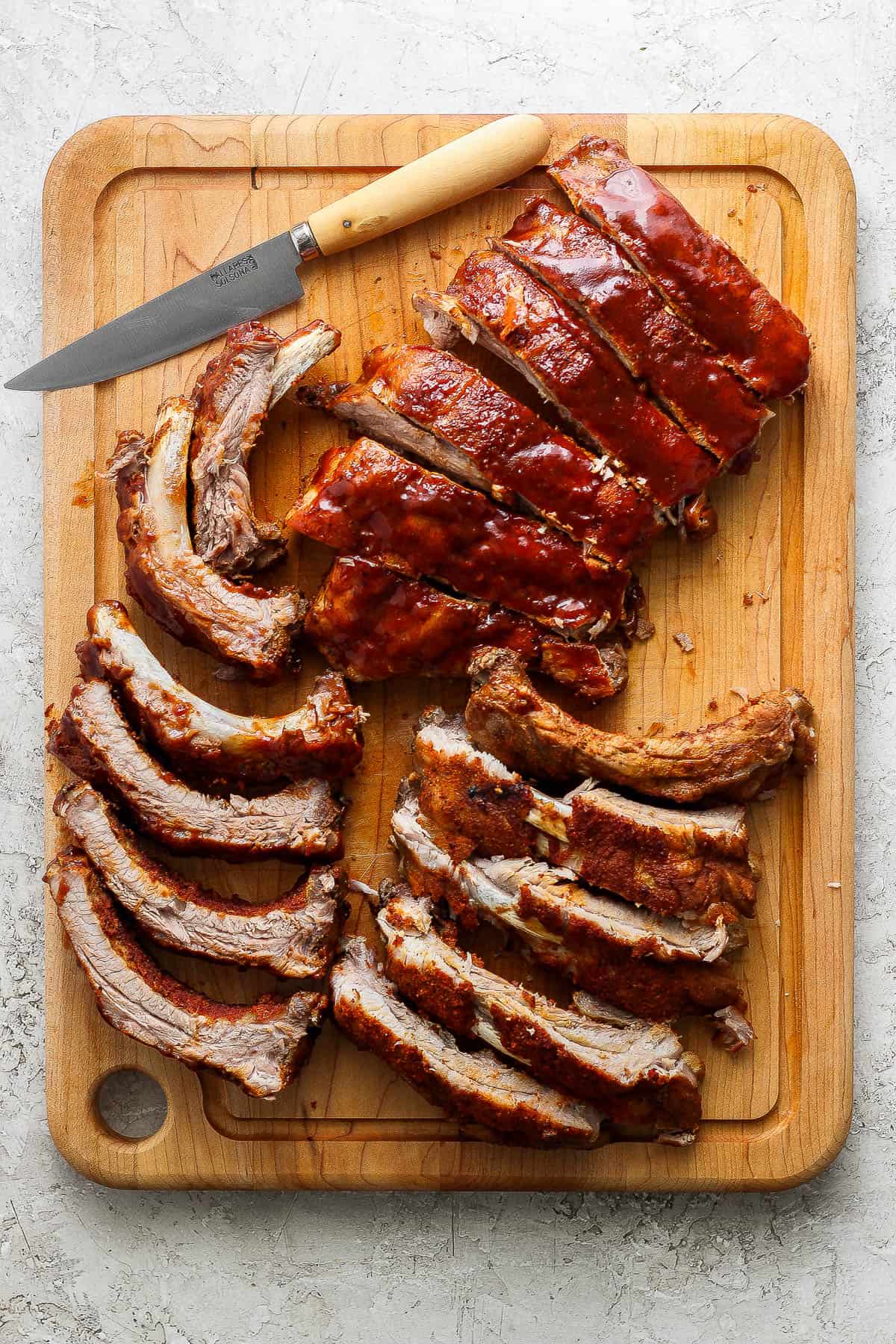Instant Pot ribs on a cutting board with a knife.