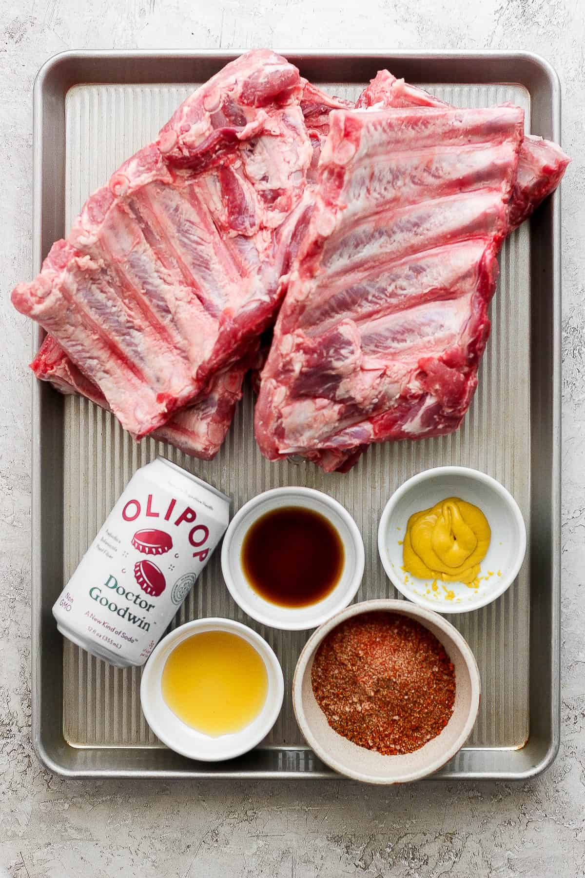 Ingredients for Instant Pot ribs on a sheet pan in separate bowls.