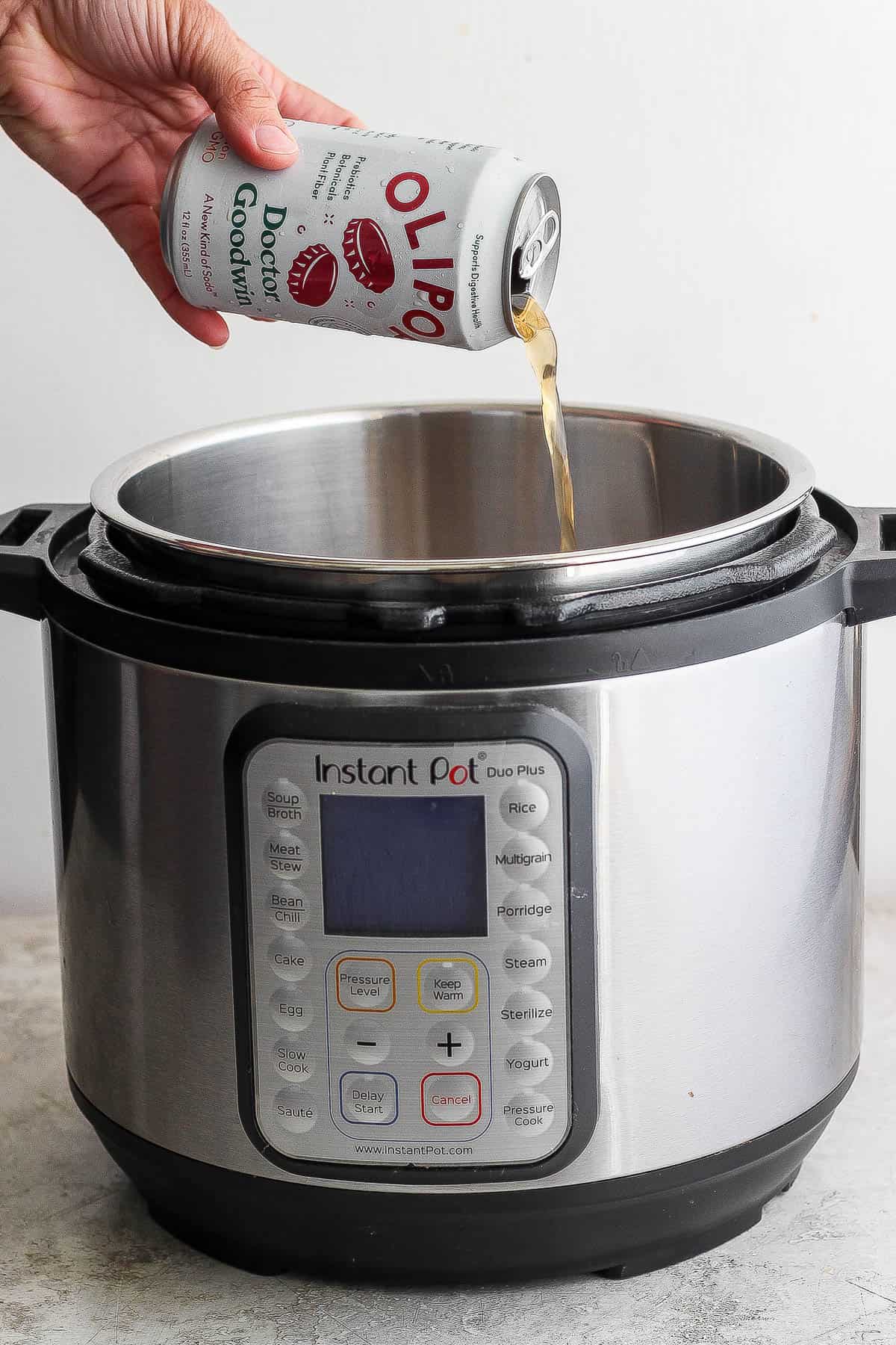 A can of Olipop Doctor Goodwin being poured into an Instant Pot.