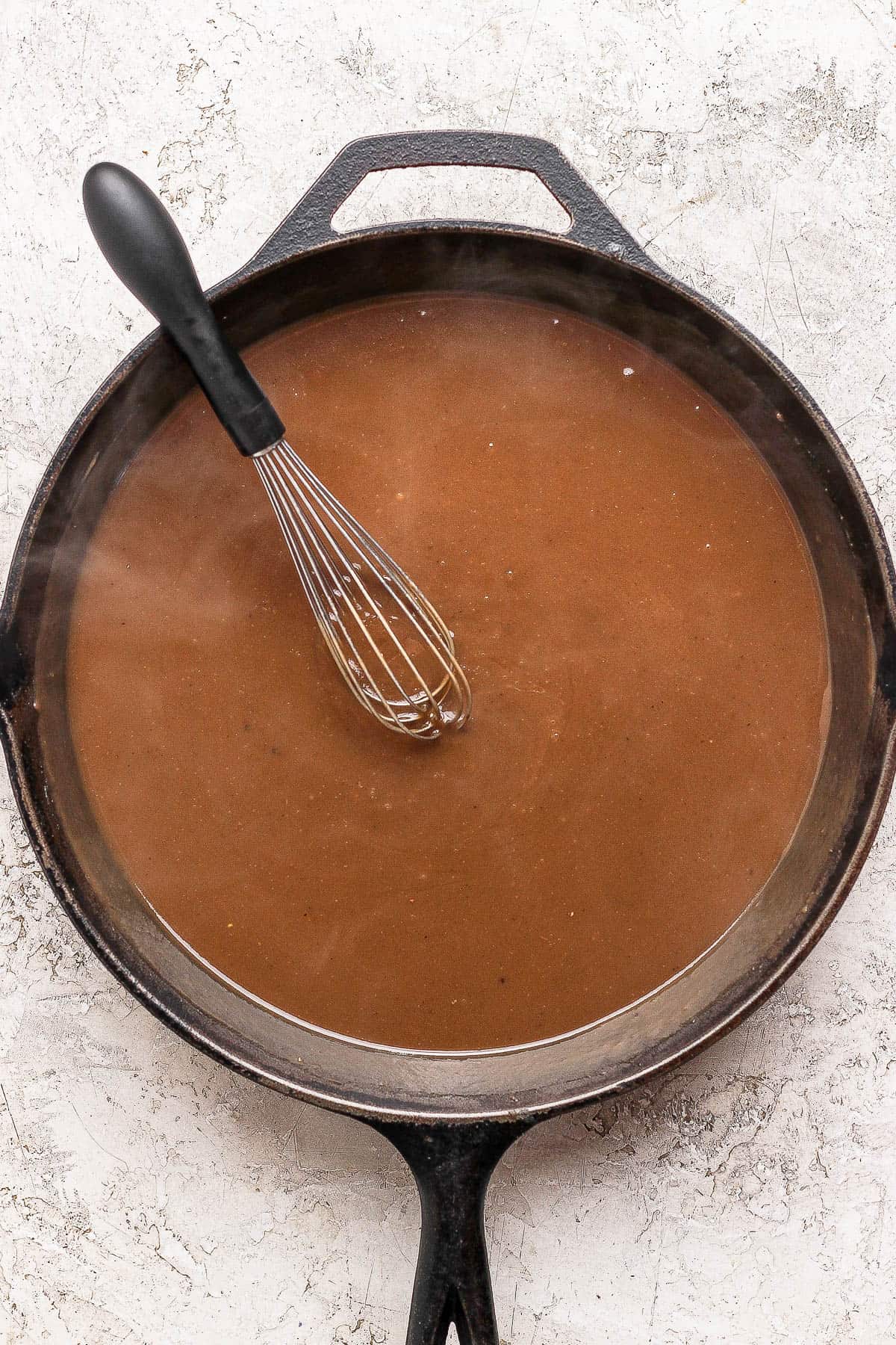 The final gravy and a whisk in a skillet.