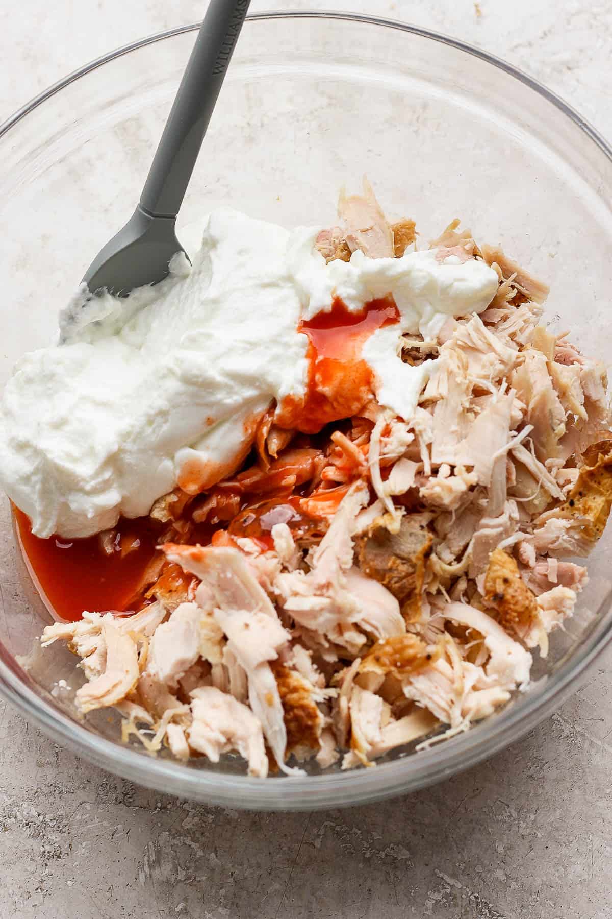 Blended cottage cheese, franks red hot sauce, and shredded chicken all added to a bowl.