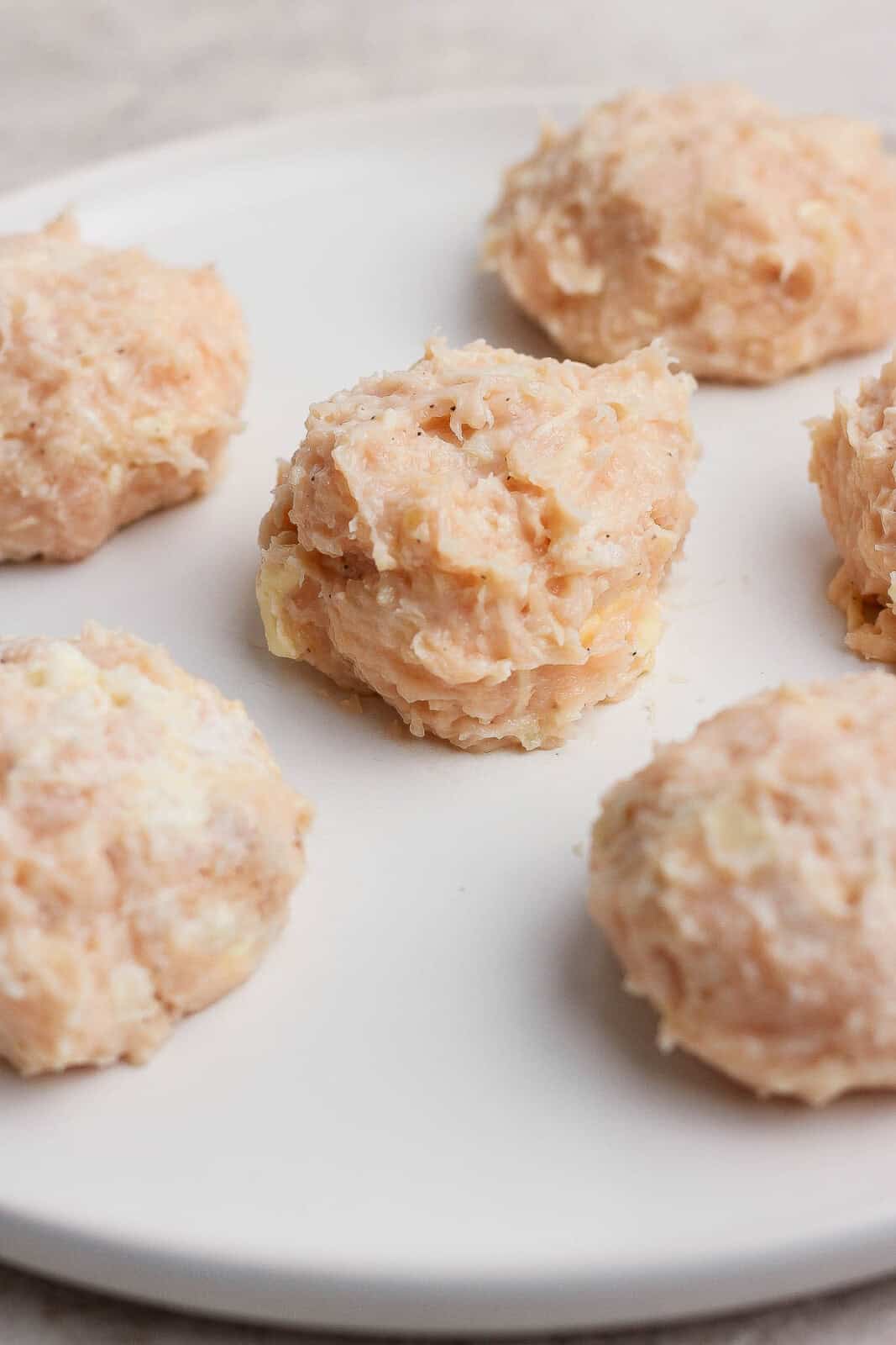 Ball of the chicken mixture for chicken parm smash tacos on a white plate.