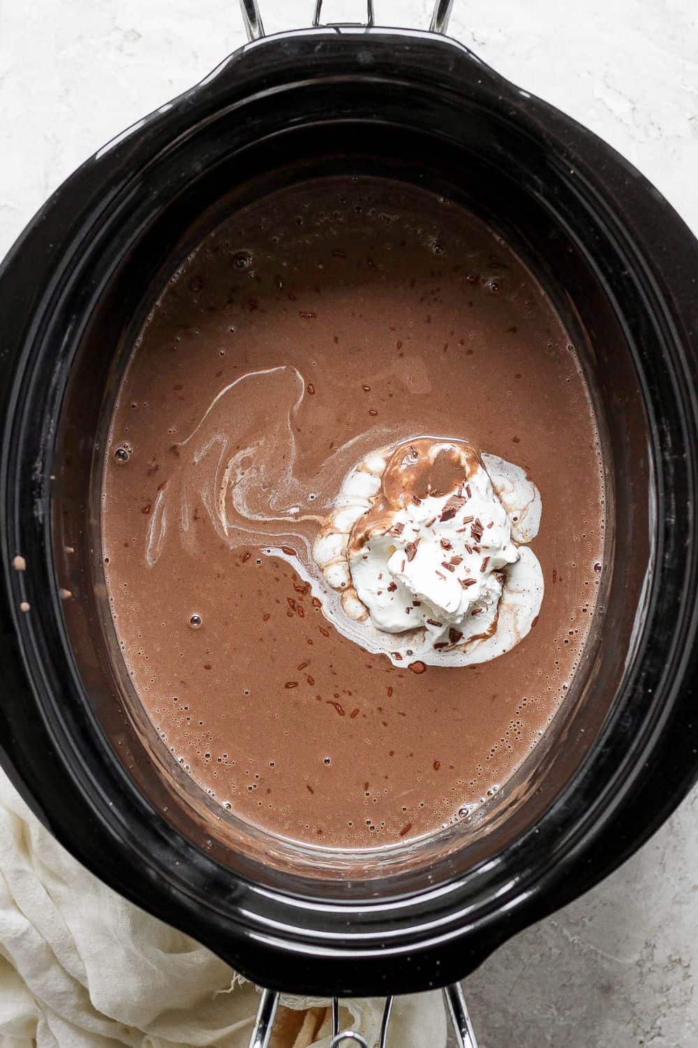 Completely melted and warmed hot chocolate in crock pot with a dollop of whipped cream.